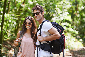 Image showing Happy couple, backpack and hiking with sunglasses in nature for adventure or outdoor journey together. Young man, woman or hiker with smile, bag and bonding for trekking or walk in forest or woods