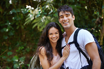 Image showing Happy couple, portrait and hiking with backpack in nature for adventure or outdoor journey together. Face of young man, woman or hiker with smile, hug and bag for bonding, trekking or walk in forest