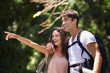 Image showing Couple, point and happy for hiking in jungle with smile for thinking, holiday and ideas on path. Man, woman and bag for trekking, direction and search in rainforest with guide at location in Colombia