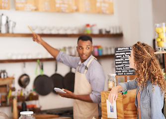 Image showing Woman, cafe and barista with pointing at menu for customer, purchase and decision in coffee shop. Waiter, small business and lady in restaurant with thinking, idea and choice for lunch order