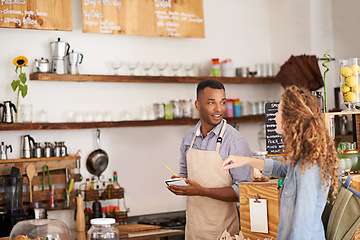 Image showing Customer, coffee shop and barista with writing at counter for order, purchase and breakfast at cafe. Female person, small business and waiter with notepad for discussion, help and food service