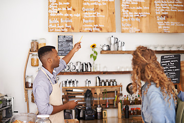 Image showing Coffee shop, customer and barista with pointing at menu for purchase, decision and service at restaurant. Waiter, small business and woman at cafe with options, discussion and choice for lunch order