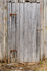 Image showing Weathered wooden door on an old rustic barn during spring