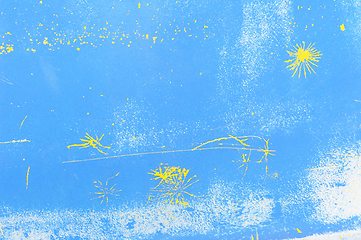 Image showing Abstract yellow paint splatters on a vibrant blue background