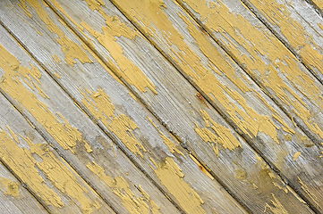 Image showing Close-up view of weathered wooden boards with peeling yellow pai