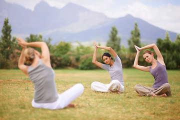 Image showing Woman, personal trainer and yoga class on field in nature for spiritual wellness, namaste or wellbeing. Young female person, yogi or fitness teacher with group in zen or balance for outdoor exercise