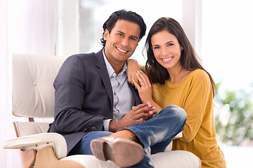 Image showing Smile, love and couple on chair in living room at home with comfortable romance and care. Happy, marriage and portrait of young man and woman sitting on sofa together in lounge at modern house.