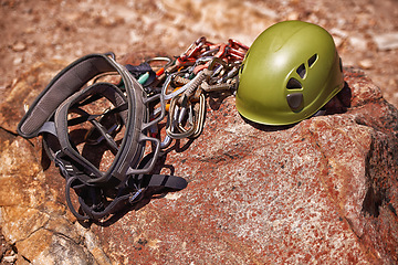Image showing Outdoor, cliff and helmet for protection in climbing with rope on mountain for athletic fitness. Gear, equipment and extreme sports for exercise, fearless and bravery in nature for workout and thrill