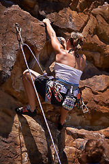 Image showing Woman, rock climbing and rope for adventure, fitness and exercise in the sun for extreme sports. Female person, training and nature for wellness, mountain and fearless activity for strength