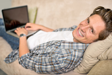 Image showing Man, portrait and laptop on sofa or relax for online browsing at home or streaming movie, internet or scrolling. Male person, face and couch at house in London for weekend, resting or entertainment