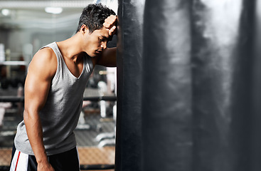 Image showing Gym, fitness and tired with man and punching bag, low energy and performance mistake or disaster. Sports, fatigue or boxer exhausted by intense body workout, challenge or fighting practice burnout