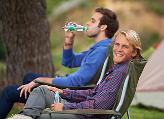 Image showing Smile, nature and portrait of men camping in outdoor field, woods or forest on vacation. Happy, travel and young male friends relaxing on chairs in park for holiday, adventure or weekend trip.