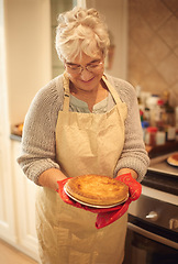 Image showing Senior woman, proud and happy with pie in kitchen, house and home with smile, dinner and food. Elderly lady, female person and looking at pastry dessert for retirement, cooking and enjoyment