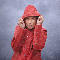 Image showing Woman, hood and portrait with rain, coat and clouds with protection in nature. Person, face and storm with cloudy, winter and waterproof hat for safety and confidence with adventure or vacation