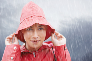 Image showing Woman, smile and portrait with rain, coat and clouds with happiness in nature. Person, face and storm with cloudy, winter and waterproof hat for protection and confidence with safety or adventure