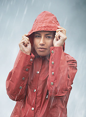 Image showing Woman, rain and portrait with storm, raincoat and safety with protection in nature. Person, face and weather with cloudy, winter and waterproof hat for confidence with adventure or cold vacation