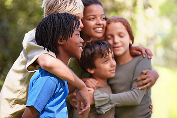 Image showing Children, together and hug with diversity in nature adventure, support and bonding on summer camp. Kids, embrace with smile for love, international and friendship in forest or woods on vacation.