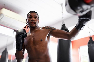 Image showing Man, boxing and bag with gloves for fitness or strong practice or fight competition, training or challenge. Black person, sweat and gym workout or exercise in Nigeria or confident, muscle or combat