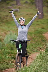 Image showing Cycling, fitness and woman success in nature for celebration, achievement and goals in training or journey. Excited person or winner with arms up for freedom, winning and yes on bicycle on mountains