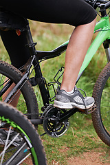 Image showing Person, legs and cyclist with bicycle in nature for paddling, cycling or outdoors sports in health and wellness. Closeup of biker, foot or shoes on mountain bike for off road travel, ride or fitness