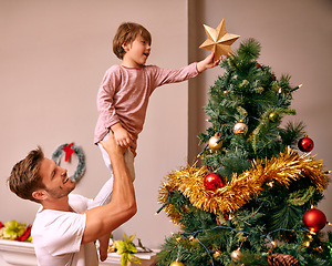 Image showing Father, son and happy with bonding by christmas tree for celebration and playing with star in the morning. Family, man and child with smile, relax and enjoying holiday season with decoration in home