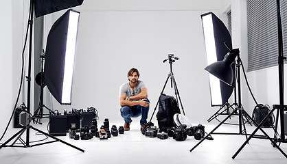 Image showing Photographer, portrait or lighting with equipment in studio for career, behind the scenes or camera. Photography, guy and confidence with electronics, flash or shooting gear for photoshoot or passion