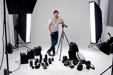 Image showing Photographer, happy or lighting with equipment in studio for career, behind the scenes or camera. Photography, guy and confidence with electronics, portrait or shooting gear for photoshoot or passion