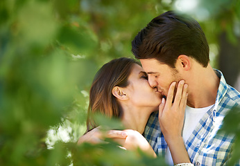 Image showing Couple, garden and kiss with love for date, bonding and romance with embrace in nature park. Man, woman and happy relationship with affection in summer for vacation, weekend or travel together