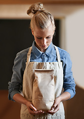 Image showing Woman, barista and paper bag with apron in coffee shop, small business owner with parcel and serious for service. Catering, hospitality and entrepreneur with eco friendly package for product in store