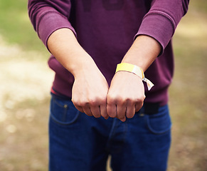 Image showing Closeup, hands and outdoor with person, music festival and bracelet for an event and partying. Vacation, outside and fist with band and weekend break with summer and holiday with sunshine and ribbon