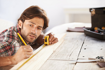 Image showing Carpenter, wood and measuring tape with man for DIY or renovation in a workshop. Craftsman, timber or measure with object for scale with construction and male person contractor with woodwork