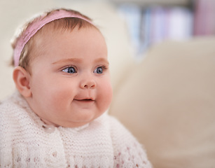 Image showing Happy, baby and face in a home with a calm, relax and sweet infant in a living room. Youth, child and house with toddler clothing in the morning ready for a nap on the sofa with joy and headband