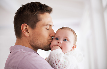 Image showing Love, father and baby with kiss in home for affection, comfort and bonding together for healthy development. Family, man and newborn child with hug, embrace and relax for parenting, care and security