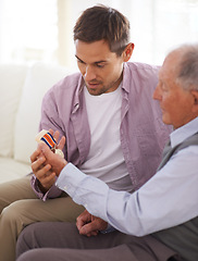 Image showing Elderly, man and son or medal on sofa with war badge, pride and honor for military hero in living room of home. Senior, veteran and retired soldier with medallion for service in army with happiness