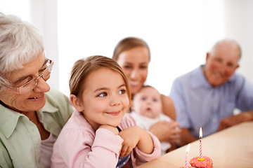Image showing Family, birthday party and cupcake with candle for celebration, mother and grandparents with children at home. Happy young girl with cake, people and smile for anniversary with dessert at event