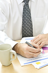 Image showing Office worker writing on reports