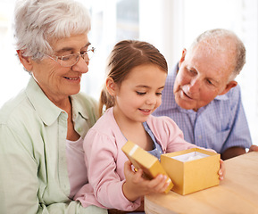 Image showing Grandparents, child and opening gift box for birthday or special event, old people and young girl for celebration. Gratitude, thanks for surprise and unboxing present with family bond and happiness