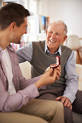 Image showing Dad, adult son and medal for present support and congratulations with celebration and bonding at home. Men in living room, family time with reward or award as gift for happiness and gratitude