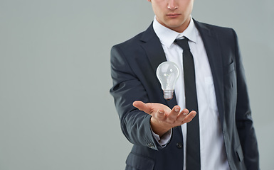 Image showing Business man, light bulb and ideas for company, entrepreneur with innovation and problem solving for energy saving. Hologram, solution and corporate goals for knowledge and power on grey background