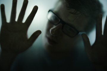 Image showing Scary, mystery and man with hands on glass, window and trapped in home. Person, shadow and figure in horror, drama or creepy aesthetic with silhouette of prisoner in house with fog on screen