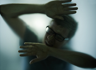 Image showing Scary, mystery and man with hands on glass, window or trapped in home. Person, shadow and figure in horror, drama or creepy aesthetic with prisoner struggling to escape house with smoke on screen