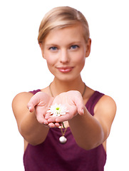 Image showing Studio, young woman and giving a daisy by white background for scent of perfume for botanicals. Model, present and new beginning with flower or love and kindness with floral plant for accountability