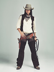 Image showing Woman, cowgirl and portrait in studio for fashion costume with confidence on grey background, weapon or outlaw. Female person, whip and hat with mockup space in Texas for dress up, old west or rodeo