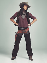 Image showing Woman, cowgirl and portrait in studio for western costume with confidence on grey background, weapon or outlaw. Female person, wild and hat with mockup space in Texas for dress up, old west or rodeo