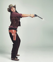 Image showing Cowgirl, woman and shooting gun, weapon or pistol in studio with costume isolated on white background mockup. Western, criminal and female person with revolver, scared or screaming in fear in Texas