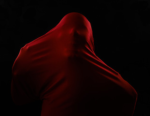 Image showing Scary, horror and person trapped in fabric for art and drama on black background in studio. Suffocating, fear and model stuck in cloth as demon, monster or ghost with terror for creative aesthetic