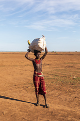 Image showing Dasanesh man carries bag on his head, Omorate, Omo Valley, Ethiopia