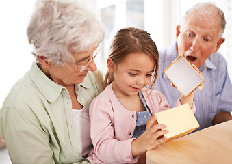 Image showing Grandparents, child and open gift box, surprise for birthday with celebration for special event and family at home. Old people with young girl, unboxing and wow reaction for present with happiness