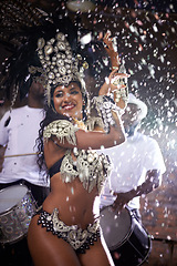 Image showing Carnival, woman and dancing in street with confetti and performance in Brazil, costume and feather head gear outdoor. Music, samba and happy for event, culture with festival entertainment and talent