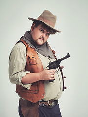 Image showing Portrait, man and cowboy with a gun, confidence and person on a white studio background. Face, model and guy with a pistol and firearm with danger and warning with Halloween costume, proud and Texas